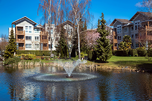An apartment community with a pond and fountain.